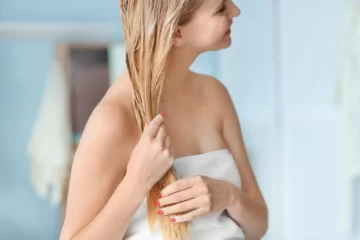 Kobieta nakładająca odżywkę do włosów